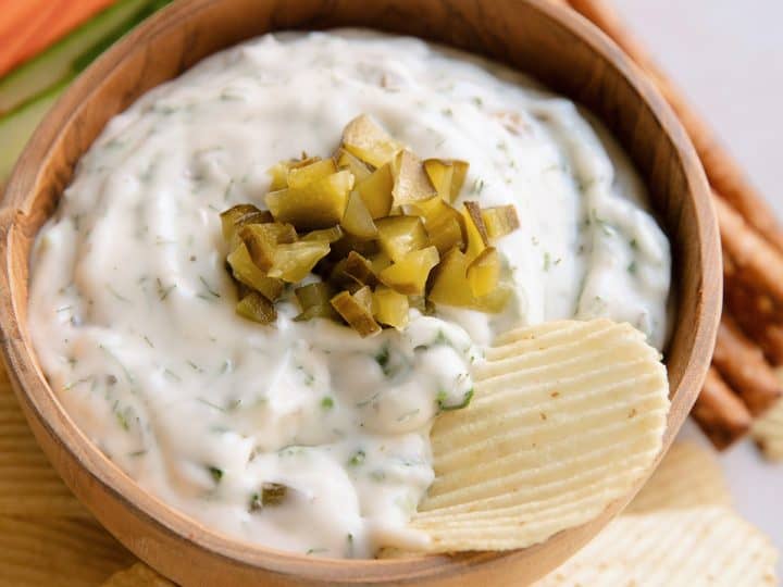 bowl of dill pick dip with a chip sitting in it